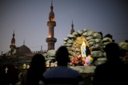 FILE - Expat worshippers pray in front of St. Mary's shrine at St. Mary's Catholic Church in Oud Metha, in Dubai, UAE, Jan. 18, 2019.