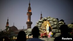 Expat worshippers pray in front of St. Mary's shrine at St. Mary's Catholic Church in Oud Metha, as Catholics await a historic visit by Pope Francis to the United Arab Emirates, in Dubai, UAE, Jan. 18, 2019.