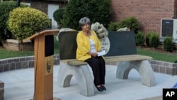 Elizabeth Eckford, one of the nine black students who first integrated Little Rock's Central High School in 1957, sits on a reconstructed commemorative bench, Sept. 4, 2018.