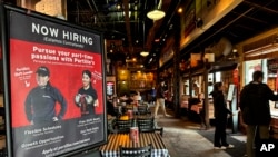 A hiring sign is displayed at a restaurant in Skokie, Illinois, Jan. 8, 2025. 