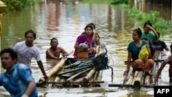 Warga yang terdampak banjir menggunakan rakit bambu saat mereka pindah ke dataran tinggi di Taungoo, wilayah Bago, Myanmar pada 14 September 2024, menyusul hujan lebat setelah Topan Yagi. (Foto: AFP)