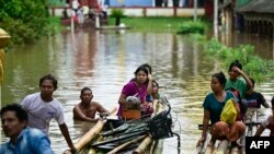 টাইফুন ইয়াগির প্রভাবে ভারী বৃষ্টিপাতে, মিয়ানমারের বাগো অঞ্চলের তাউঙ্গুতে উঁচু জায়গায় যাওয়ার সময় বন্যায় ক্ষতিগ্রস্ত বাসিন্দারা বাঁশের ভেলা ব্যবহার করে। (১৪ সেপ্টেম্বর, ২০২৪) 