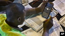 FILE - In this March 6, 2013 file photo, an electoral worker engages in a part of the tally verification process at the National Tallying Center in Nairobi, Kenya. 