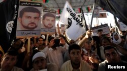 People hold posters of senior al Qaida figure Abu Anas al-Libi (L) during a demonstration over his capture by U.S. authorities, in Benghazi, Oct. 11, 2013. 