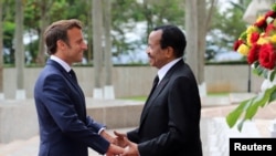 Cameroon's President Paul Biya welcomes his French counterpart Emmanuel Macron at the presidential palace in Yaounde, Cameroon, July 26, 2022