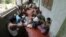 People eat food distributed at a Buddhist monastery used as a collective shelter for those displaced by recent violence in Sittwe, June 17, 2012.