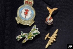 Michael Woods, 100-year-old World War II veteran wears a pin featuring a Lancaster Bomber during an interview in Dunstable, Bedfordshire, England, Nov. 5, 2024.