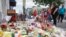 Mourners bring flowers to a makeshift memorial, Aug. 6, 2019, for the slain and injured in the Oregon District after a mass shooting early Sunday in Dayton, Ohio.