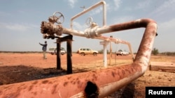 FILE - Oil spills onto the ground from an oil well head at an oil field in South Sudan, March 3, 2012. A pipeline burst in a remote part of Northern Liech state on Nov. 7, reportedly forcing the evacuation of more than 2,000 South Sudanese villagers.
