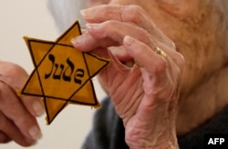 FILE- German Holocaust survivor Margot Friedlander holds her Jewish Star of David she had to wear in Nazi Germany, as she takes part in a round table on a cohabitation without anti-semitism and islamophobia, on November 8, 2023 at the presidential Bellevue Palace in Berlin.