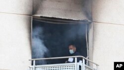 A man inspects a burned nursing home after a fire in the municipality of Moncada just north of Valencia, Spain, Jan. 19, 2022.