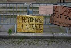 A poster reading "interminable intermission" is pictured outside the occupied Odeon theater, March 5, 2021, in Paris. Out-of-work French culture and tourism workers are occupying the theater to demand more government support during the pandemic.