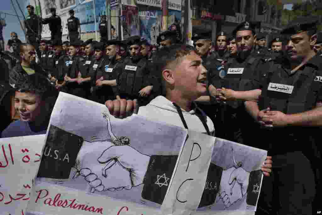 Polisi menghalangi para demonstran Palestina dalam protest menentang Presiden AS Barack Obama di kota Ramallah, Tepi Barat (21/3). (AP/Bernat Armangue)