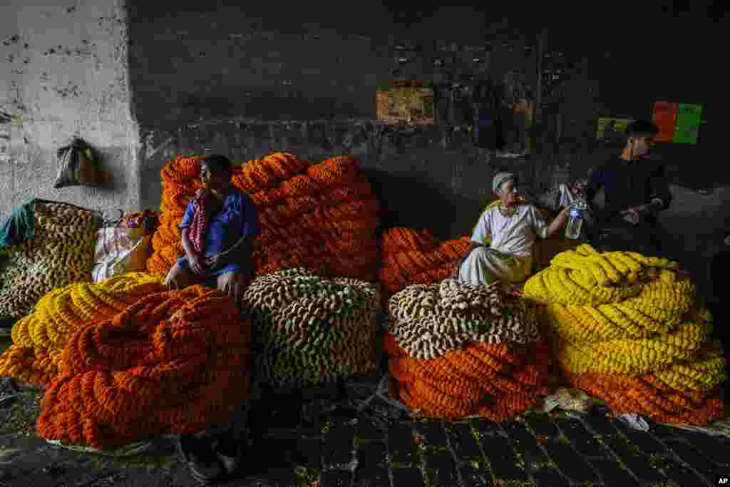 Vendors with marigold garlands await customers at a wholesale flower market in Kolkata, India.