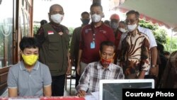 Walikota Solo, Hadi Rudyatmo ( baju rompi dengan bendera merah putih) mendampingi Menteri Sosial ( berdiri -baju merah), mengecek langsung penyaluran Bantuan Sosial Tunai di Solo, akhir Mei 2020. (Foto: Pemkot Surakarta)