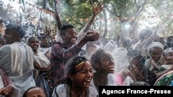 Ethiopian Orthodox worshippers get sprinkled with water in the compound of Fasilides Bath during the celebration of Timkat, the Ethiopian Epiphany, in the city of Gondar, Ethiopia, on January 19, 2022. 