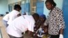 FILE - Health workers take a blood sample from a child in Gusau, northern Nigeria.