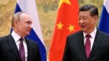 FILE - Chinese President Xi Jinping, right, and Russian President Vladimir Putin talk to each other during their meeting in Beijing, China on Feb. 4, 2022.