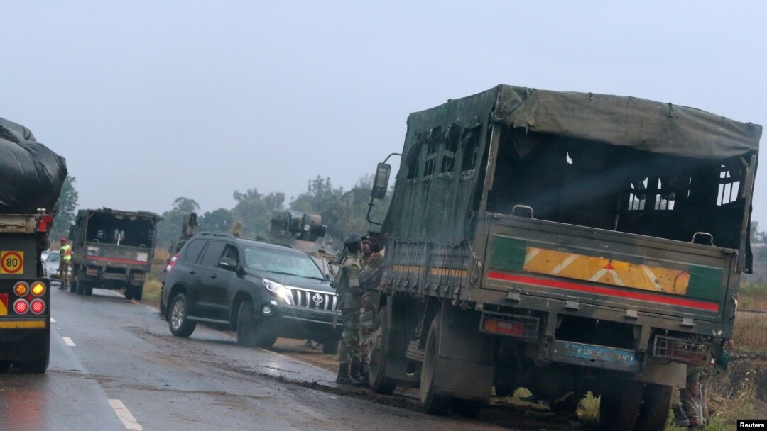 Tentara berjaga-jaga di samping kendaraan militer di luar Kota Harare, Zimbabwe, 14 November 2017. 