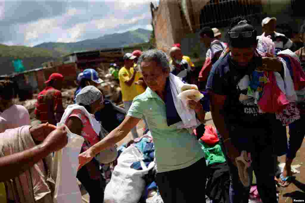 Las personas afectadas por las devastadoras inundaciones que siguieron a las fuertes lluvias reciben ropa donada en Las Tejerias, en el estado de Aragua, Venezuela, el 11 de octubre de 2022. REUTERS/Leonardo Fernandez Viloria