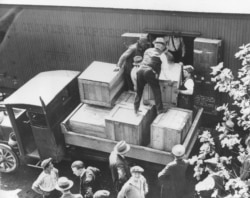 FILE - In this May 15, 1929, photo, authorities unload cases of whiskey crates labeled as green tomatoes from a refrigerator car in Washington, D.C.
