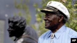 FILE - Chuck Berry sits on a stage next to a statue of himself during its dedication, July 29, 2011, in University City, Mo. The statue of the St. Louis native was dedicated near Blueberry Hill, the University City club where he performed monthly. 