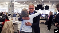 Pittsburgh Post Gazette retired Executive Editor David Shribman, center right, hugs city editor Lillian Thomas in the paper's downtown Pittsburgh newsroom after it was announced that the paper's staff coverage of the shooting at the Tree of Life Synagogue last October was awarded