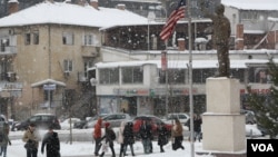 A statue of former US President Bill Clinton looking towards Bill Clinton Boulevard on a snowy January afternoon in Pristina, Kosovo, Jan. 18, 2016. (P.W. Wellman/VOA)