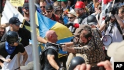 FILE - White nationalist demonstrators clash with counterdemonstrators at the entrance to Lee Park in Charlottesville, Va., Aug. 12, 2017. 