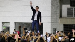 Opposition leader Juan Guaido waves to supporters during a rally at Bolivar Plaza in Chacao, Venezuela, Feb. 11, 2020.