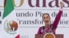 President Claudia Sheinbaum gestures to the crowd during an event marking her first 100 days in office, at the Zócalo, Mexico City's main square, in Mexico City, Jan. 12, 2025. 