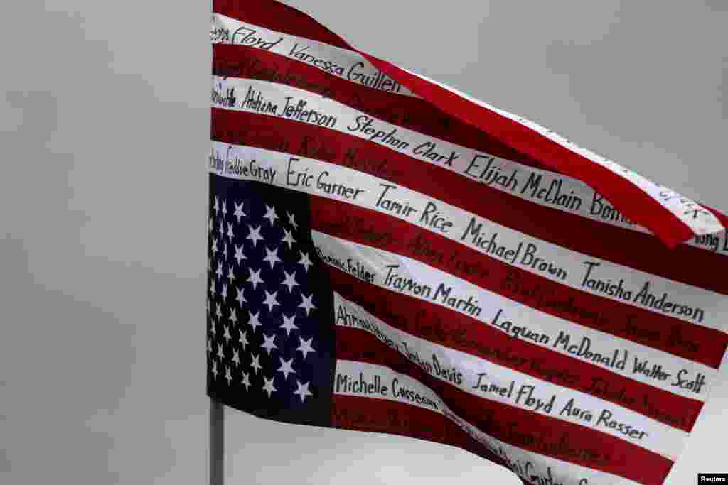 A U.S. flag carried upside down with the names of people of color killed in police custody and in other incidents is seen before a protest march, days after Daunte Wright was shot and killed by a police officer, in Brooklyn Center, Minnesota, April 13, 2021.