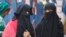 FILE - Indian Muslim women talk while walking through a market in Ahmadabad, India, Dec. 29, 2017. 