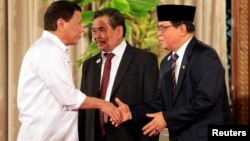 Presiden Filipina Rodrigo Duterte (kiri) berjabat tangan dengan pemimpin Moro Islamic Liberation Front (MILF) Al Haj Murad Ebrahim di Manila, 17 Juli tahun 2017 (foto: dok). 