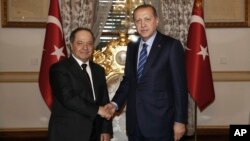 Turkey's President Recep Tayyip Erdogan, right, shakes hands with Iraqi Kurdish leader Massoud Barzani, in Istanbul, Feb. 26, 2017.