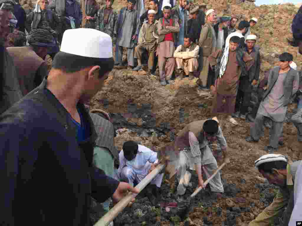 Warga mencari penyintas menyusul tanah longsor masif yang menimbun satu desa di provinsi Badakhshan, timur laut Afghanistan (2/5). (AP/Homayoon Rahmani).