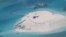 FILE - In this photo taken by surveillance planes and released May 15, 2014 by the Philippine Department of Foreign Affairs, a Chinese vessel, top center, is used to expand structures and land on the Johnson Reef at the Spratly Islands in the South China Sea, Philippines. 