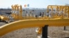 FILE - Men stand next to pipelines of the national natural gas distribution network outside Ungheni, Moldova, March 4, 2015. 