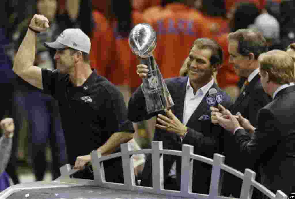 Pemilik klub Baltimore Ravens Stephen J. Bisciotti (kanan) memegang Piala Vince Lombardi didampingi pelatih John Harbaugh setelah kemenangan tim tersebut dalam pertandingan final sepakbola NFL Super Bowl XLVII melawan San Francisco 49ers, Minggu (3/2) di New Orleans. (AP/Gerald Herbert)