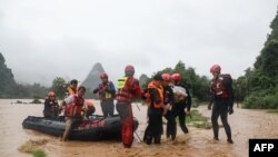 Regu penyelamat mengevakuasi warga di kawasan yang terdampak banjir pasca hujan lebat di Yangshuo, di wilayah selatan Guangxi, China, 7 JUni 2020. (Foto oleh STR / AFP) / China
