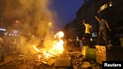 Anti-government protesters shout slogans as they stand on barricades in Istanbul June 16, 2013.