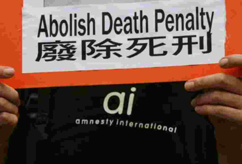 A protester from human rights group Amnesty International, carrying a placard demanding the abolition of death penalty in mainland China, demonstrate outside a Chinese liaison office in Hong Kong July 14, 2005. Amnesty International estimates that China e