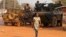 A woman walks past French peacekeeping troops in a street of the capital Bangui, Central African Republic, Jan. 17, 2014.