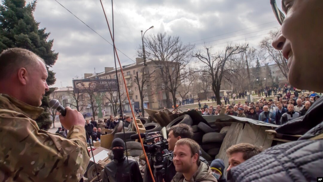 Seorang aktivis pro-Rusia berorasi di hadapan para pemrotes di sekitar barikade yang dibangun di depan gedung kantor keamanan regional di Luhansk, Ukraina (9/4).