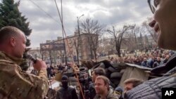 Seorang aktivis pro-Rusia berorasi di hadapan para pemrotes di sekitar barikade yang dibangun di depan gedung kantor keamanan regional di Luhansk, Ukraina (9/4).