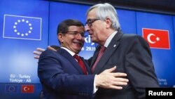 PM Turki Ahmet Davutoglu (kiri) dan Presiden Komisi Eropa, Jean Claude Juncker usai konferensi pers pasca KTT Uni Eropa-Turki di Brussels, Belgia hari Minggu (29/11).