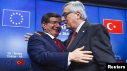 PM Turki Ahmet Davutoglu (kiri) dan Presiden Komisi Eropa Jean Claude Juncker bersalaman setelah KTT Turki-Uni Eropa di Brussels, Belgia (foto: dok). Uni Eropa mendesak Turki melakukan reformasi di daerah kunci. 