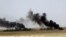 This picture released on Wednesday, May 20, 2015 on the website of Islamic State militants, shows black columns of smoke rising through the air during a battle between Islamic State militants and the Syrian government forces on a road between Homs and Pal