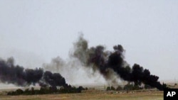 This picture released on Wednesday, May 20, 2015 on the website of Islamic State militants, shows black columns of smoke rising through the air during a battle between Islamic State militants and the Syrian government forces on a road between Homs and Palmyra.