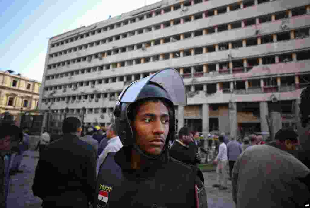 A police officer stands guard after a car bomb attack at the Egyptian police headquarters in downtown Cairo, Jan. 24, 2014.